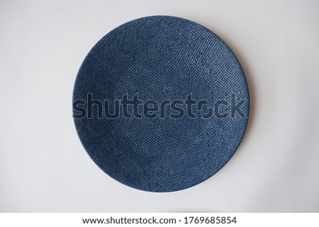 Top view of navy blue ceramic plate on white background, isolated.