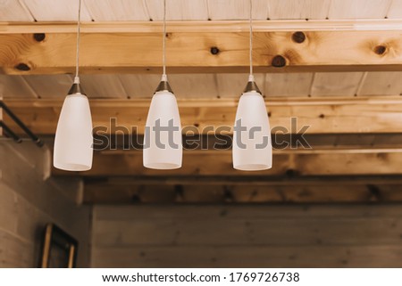White lamps on the ceiling of a wooden house. Interior decor, rustic comfort, summer mood, relaxation by the countryside.