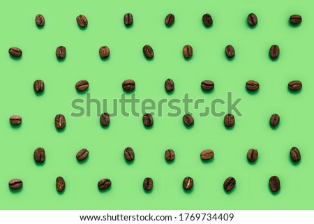 Lots of coffee beans stacked in rows. Pattern in a minimalistic style. Isolated on background. Isolated on a green background