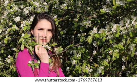 Portrait of a lovely young girl on a walk in a flowering spring park