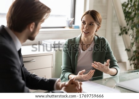 Motivated diverse Caucasian colleagues or partners talk discuss business ideas at meeting in office, confident female employee speak at interview with employer or boss, make good first impression Royalty-Free Stock Photo #1769759666