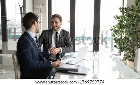 Excited Caucasian male business partners handshake close deal make agreement after successful negotiation in office, smiling businessmen shake hands get acquainted at meeting, partnership concept