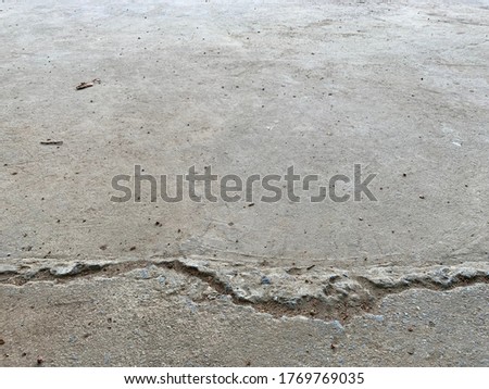 The concrete floor is dirty, with cracks in a long way.