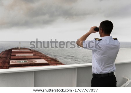 Navigator on the bridge of a large bulk carrier, doing lookout at the horizon with his binoculars

 Royalty-Free Stock Photo #1769769839