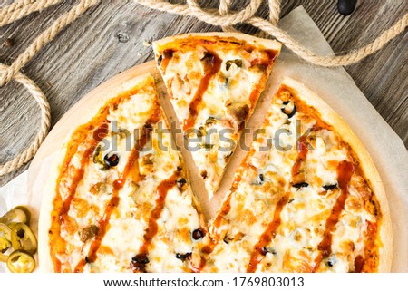 Bright striped pizza on a wooden tray with a slice cut off
