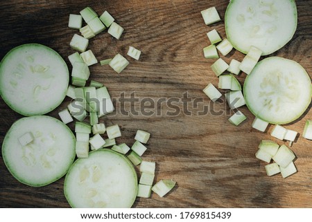 fresh green zucchini with slices isolated on a wooden background