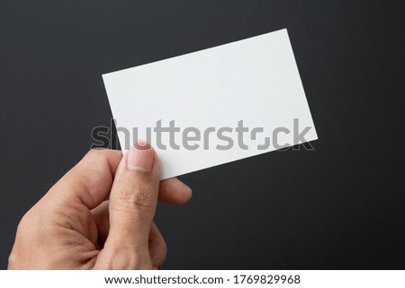 Hand holding Business card on a black background