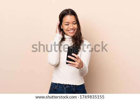 Young Colombian girl over isolated background making a selfie