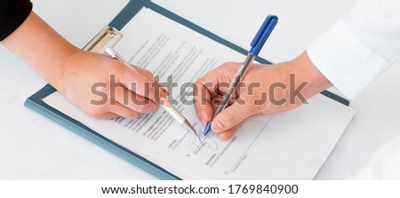Close-up of hands signing contract agreement