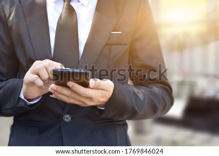 Closeup of businessman hand using mobile phone. Idea for business, technology and online marketing.
