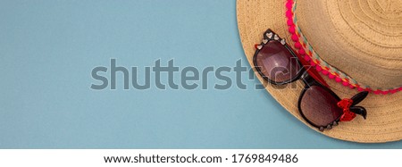 beach accessories on a blue background, beach slippers, hat, goggles. Copy space, text space. Holidays at sea