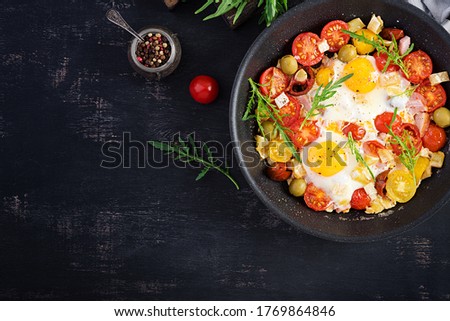 English breakfast - fried eggs, ham, tomatoes and arugula. American food. Top view, overhead, copy space