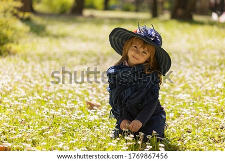 a little girl with a hat in a flower field
