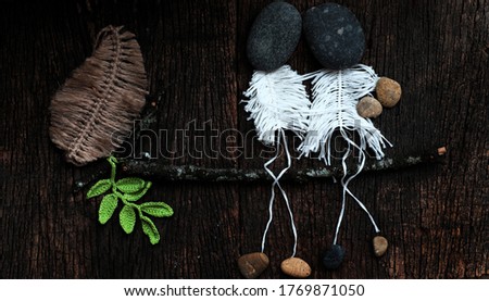Top view funny, cute concept with joke for love concept background, couple as skeleton from macrame handmade sit on branch of tree, head from pebble so art,  happy when fall in love on dark wooden 