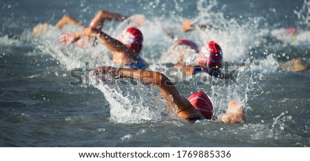Competitors swimming out into open water at the beginning of triathlon Royalty-Free Stock Photo #1769885336
