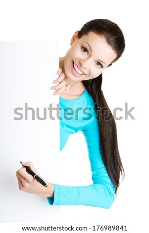 Happy beautiful woman writing with a pen on blank board. Student or businesswoman. 