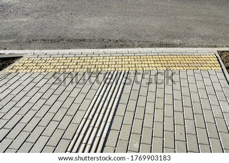 new paved walkway with guidelines for visually impaired people