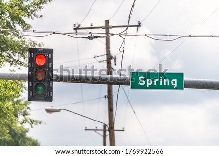Hot Springs, Arkansas Spring road sign green text on street in downtown with red traffic signal light closeup