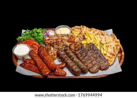 Isolated / Transparent Greek / Arabic Restaurant Grilled Meat Platter, Lamb, Beef, Chicken, Pork Kebab Skewers Sauce Tahini Feta Fries Chips Salad Sausages