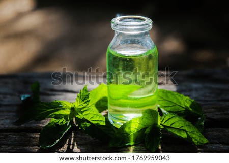 peppermint leaves and oil in a small jar closeup