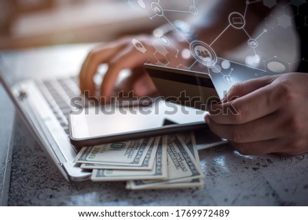 Side view of male hands holding credit card typing numbers on computer keyboard while sitting at home  soft focus, flare sun light, cross process image