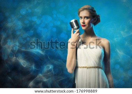 attractive female singer with a microphone behind her abstract background