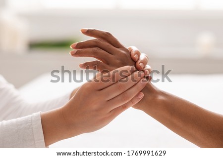 Hand massage. Female therapist pressing specific spots on black lady palm. Professional health and wellness acupressure manipulations, closeup Royalty-Free Stock Photo #1769991629