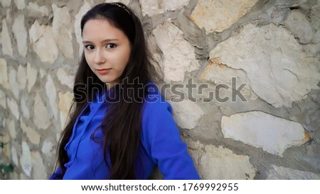 Pensive girl in a blue jacket with a mysterious look.