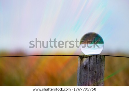 Wooden post on the dikes of Katwijk, Netherlands and lens ball