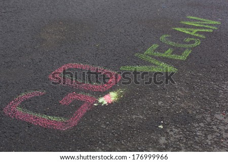 Words Go Vegan drawing on asphalt background. Veganism concept.
