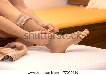 Female putting thrombosis stockings on