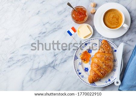 Croissant with coffee, jam, butter and French flag. Continental breakfast concept. Copy space. Top view.