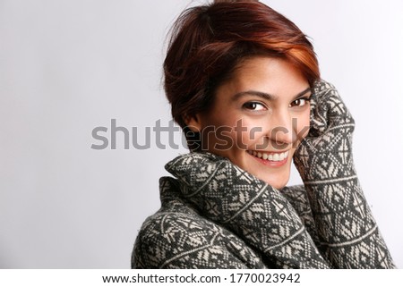 Beautiful girl with fantasy color sweater smiles happy, isolated on white background