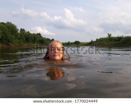 a girl with seaweed on her head is swimming in the river