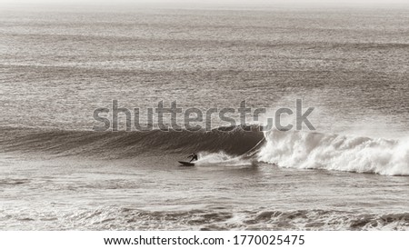 Surfer Surfing bottom turning on ocean wave in vintage sepia tone  overlooking  panoramic photo. Royalty-Free Stock Photo #1770025475