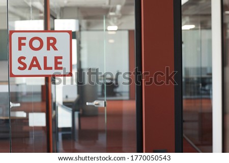 Graphic background image of red For Sale sign on glass door of empty office rental, copy space