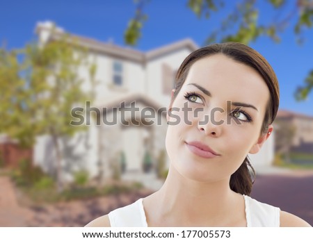 Thoughtful Pretty Mixed Race Woman In Front of House Looking up and to the Side.