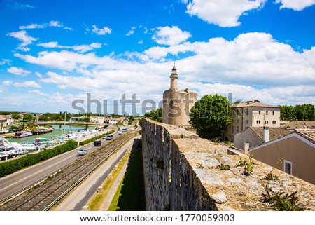 Shipping channel flows into the Mediterranean Sea. France. Antique walls of the medieval port city of Aigues-Mortes. The concept of historical and photo tourism