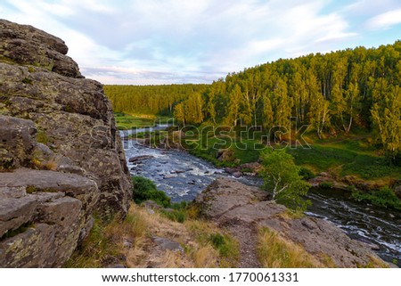 soft sun rays in evening over beautiful valley with mountain river and many rapids. Ural, Russia,