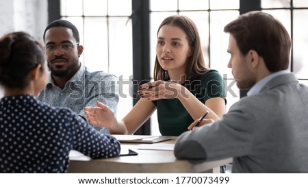 Young professionals multi ethnic company employees gathered together solving issues, new project discussion during briefing, meeting talk for giving information or instructions by team leader concept Royalty-Free Stock Photo #1770073499