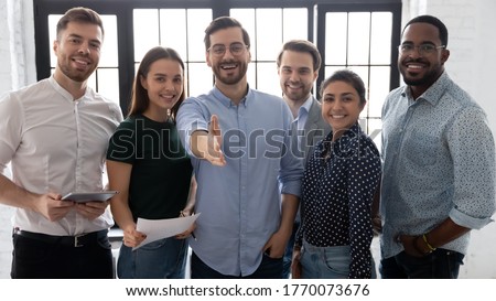 Millennial male leader stretch out his hand for handshake welcoming new employee invites newcomer to corporate team, group showing amity, human resources, boss greets clients express respect concept Royalty-Free Stock Photo #1770073676