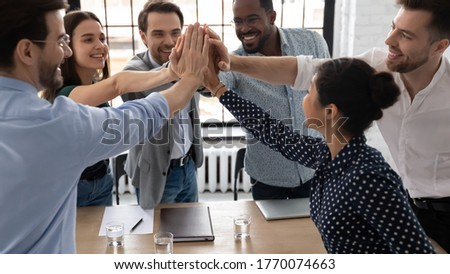 Group of excited multi-ethnic office staff members stack palms together express unity, giving high five gesture sharing department success, sales increase, career growth, team building spirit concept Royalty-Free Stock Photo #1770074663