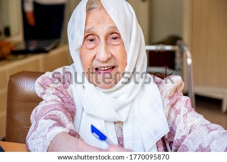 Old woman portrait studying ,writing and learning using tablet and notebook