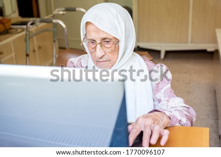 Old woman using laptop for working and communicating