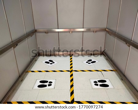 Footprint sign on a floor in public elevator for standing to prevented people from Covid-19. Social distancing sign concept. 