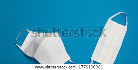 Two white reusable medical masks on dark blue background isolated Hygienic surgical, antiviral mask Concept of protective equipment against coronavirus, pandemic, closeup top view Banner for web site