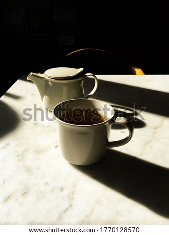 cup of tea or coffee and tea pot on a table