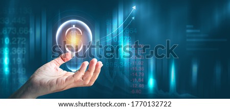 Digital marketing of sales and economic growthing. Businessman holding dollar sign with panoramic business strategy abstract graphic background and copy space.