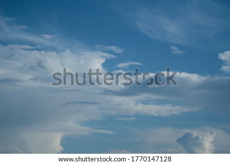 White cirrus clouds on a background of dark blue sky.