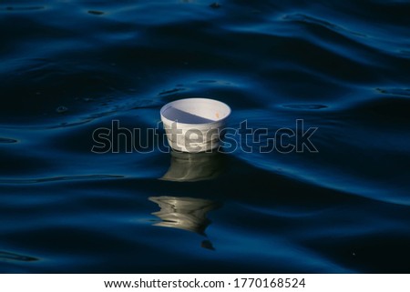 Foam cup marine waste in the sea that is created by humans.Causing sewage and germs.